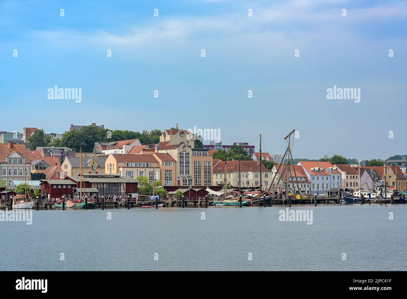 Flensburg, 25. Juli 2022: Museumshafen und alte Werft am Fjord, Stadtbild mit Stadthäusern unter einem trüben blauen Himmel, Kopierraum, se Stockfoto