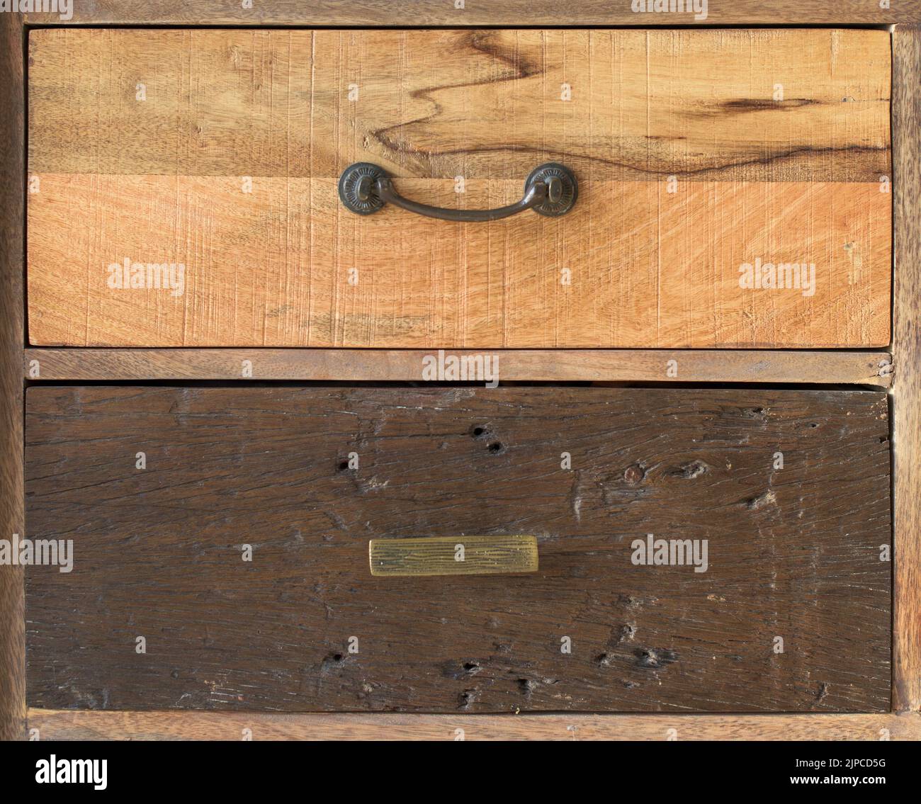 Eine antike hölzerne Kommode mit Metallgriffen, verschiedene alte Holzkisten Stockfoto