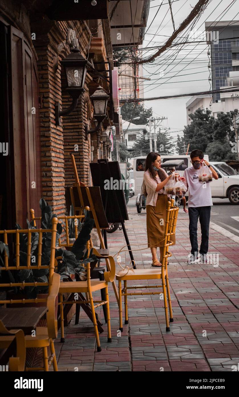 Eine wunderschöne Aufnahme von zwei Menschen, die auf den Philippinen vor einer Staffelei auf der Straße stehen Stockfoto