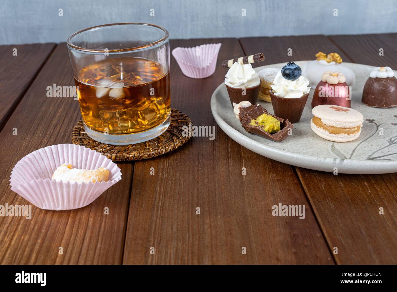 Ein Glas Whiskey mit Eis und raffinierte brasilianische Hochzeitsbonbons. Stockfoto