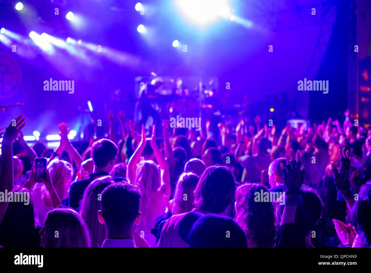 Menschenmenge, die während des Konzerts die Arme hochhebt Stockfoto