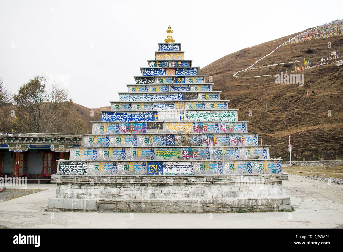 Tibetische Stupa in Form einer Pyramide aus bunten Steinplatten, gedruckt mit buddhistischer Schrift in tibetischer Standardsprache, Kloster Tagong. Stockfoto