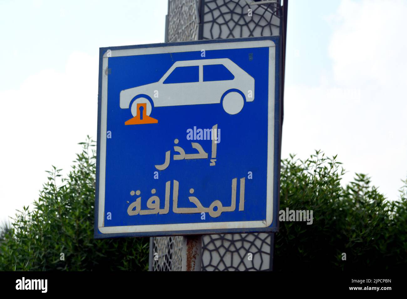 Übersetzung der arabischen Inschrift (Vorsicht vor Verkehrsverstößen), ein Verkehrsschild zeigt einen Sperrbereich für das Parken der Fahrzeuge und ein Auto mit einem Stockfoto