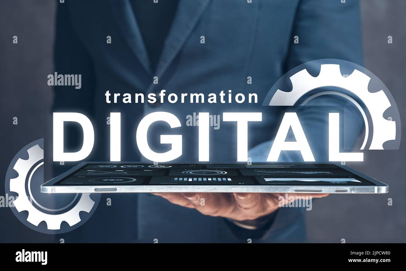 Digitale Transformation. Geschäftsmann hält in seiner Hand Tablet mit Text digitale Transformation und Zahnräder. Digitale Modernisierung und Geschäftsprozesse Stockfoto