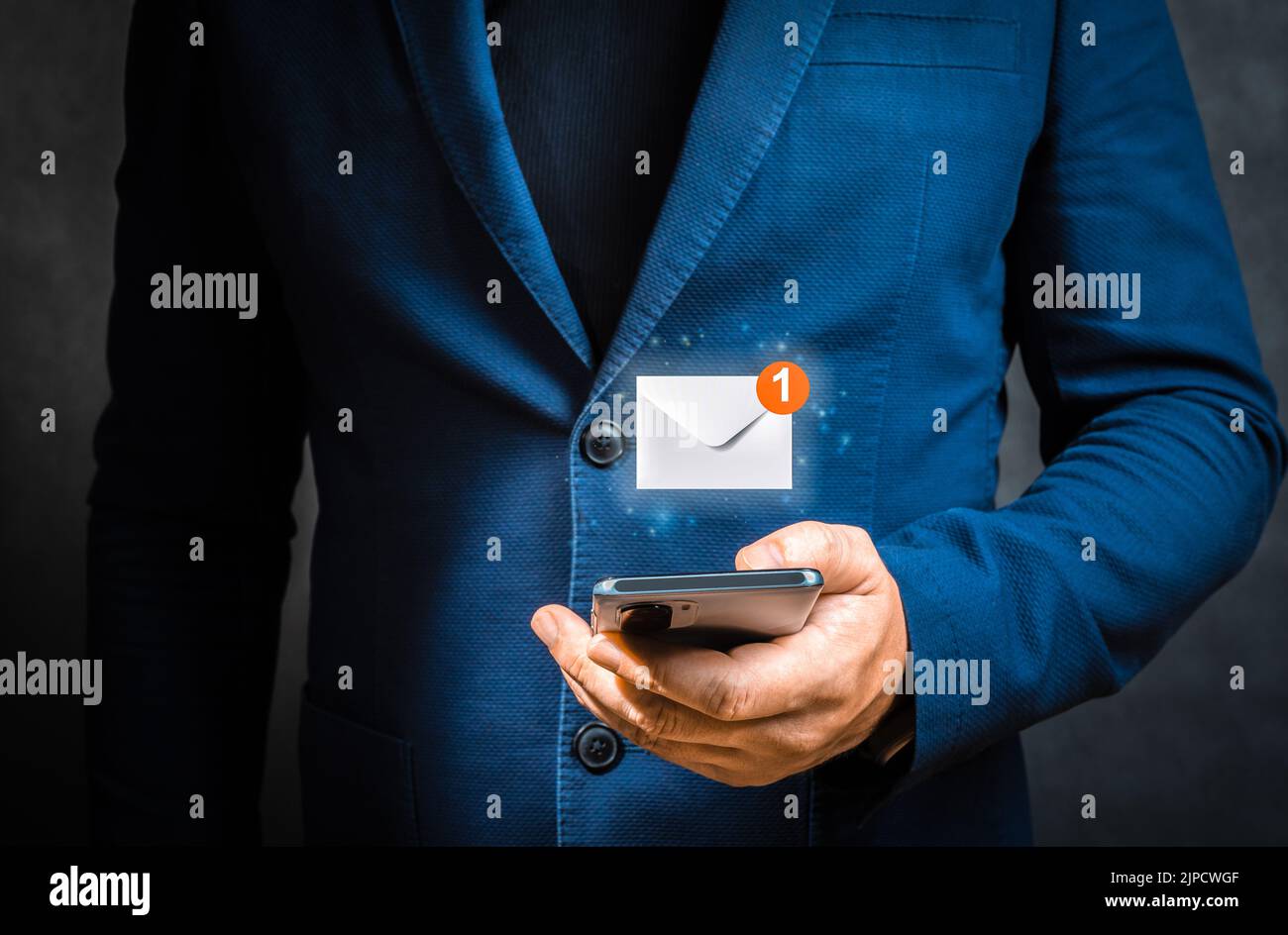 Geschäftsmann hält Handy mit virtuellem Brief Symbol für Application Notification Alert Konzept. Hand des Geschäftsmannes mit Smartphone für E-Mail mit Stockfoto