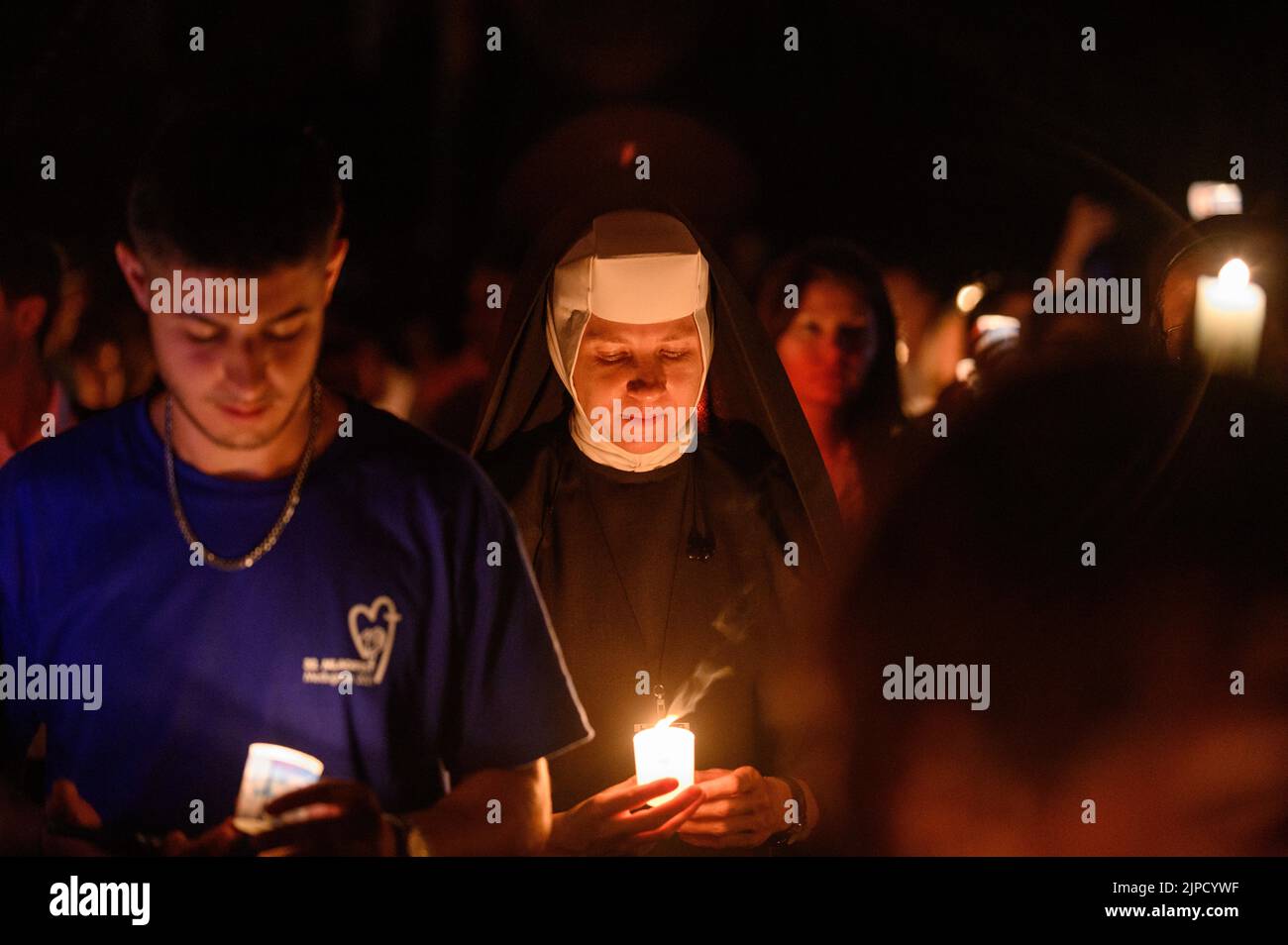 Menschen mit Kerzen beten und singen während der Verehrung des Heiligen Kreuzes nach der Heiligen Messe während des Mladifestes in Medjugorje. Stockfoto