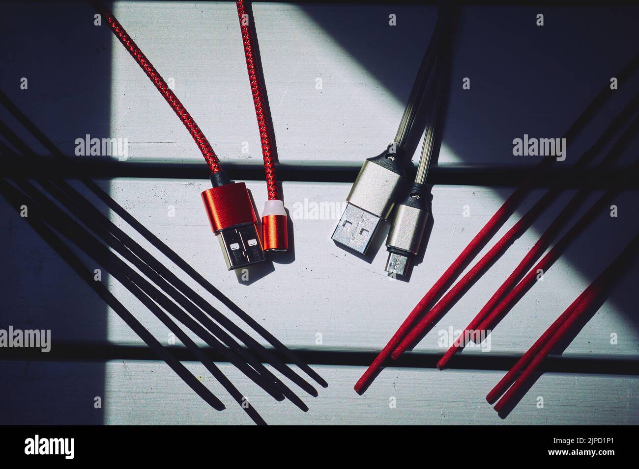 Digitale Meditation. Rot-schwarze usb-Kabel, rot-schwarze Räucherstäbchen. Stockfoto