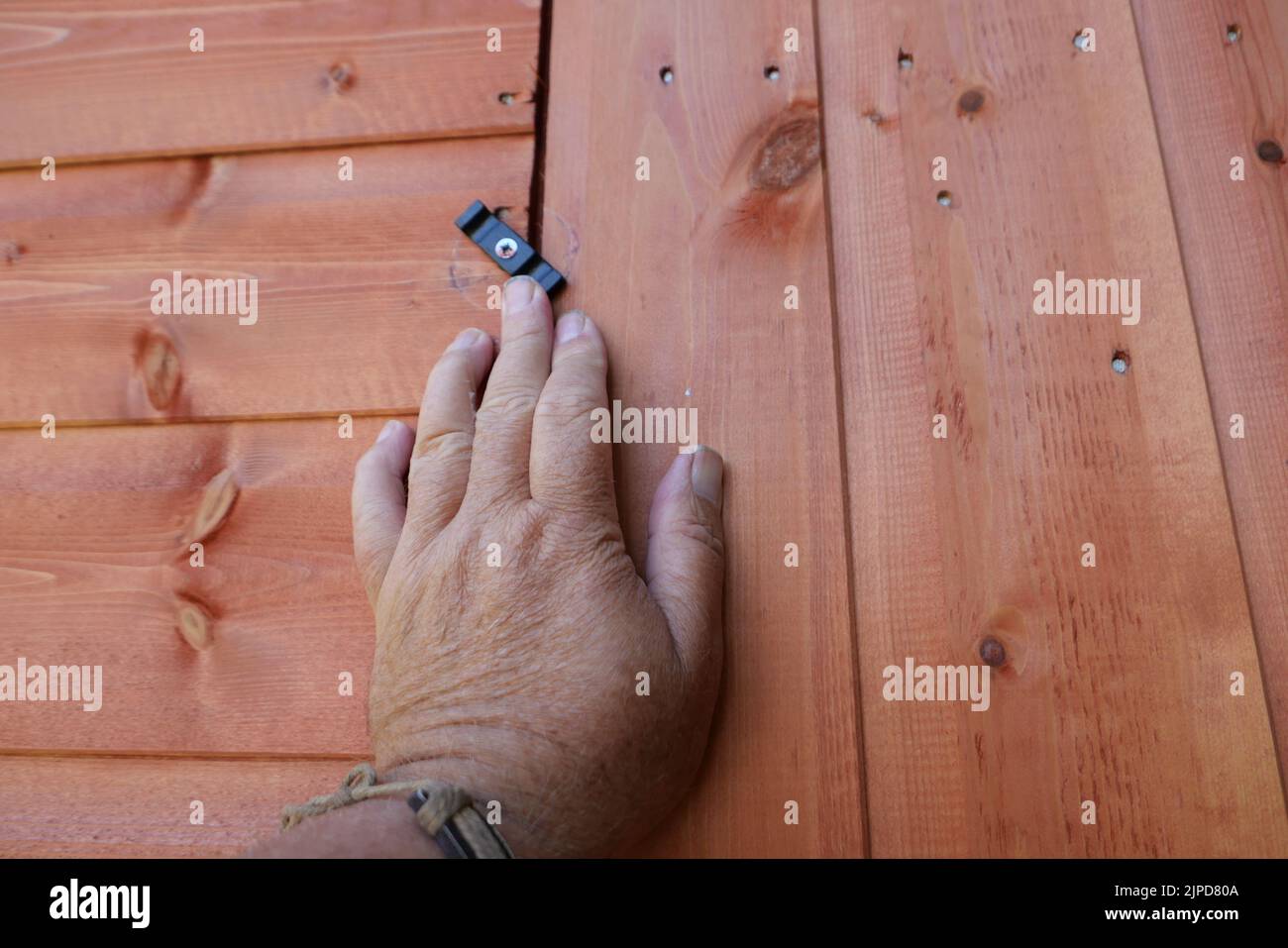 POV Hand öffnen oder schließen eine neue Holzschuppen Tür Stockfoto