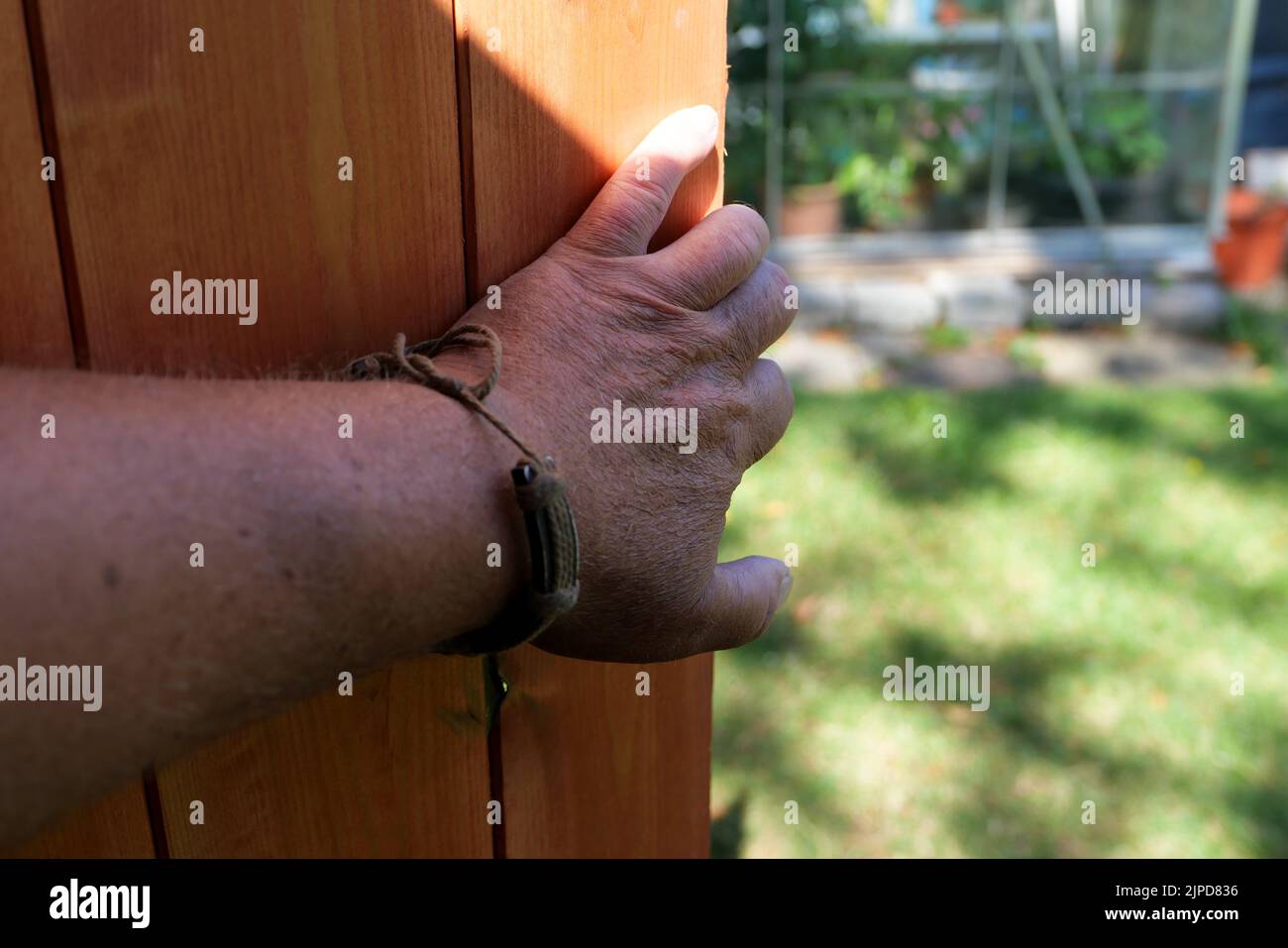 POV Hand öffnen oder schließen eine neue Holzschuppen Tür Stockfoto
