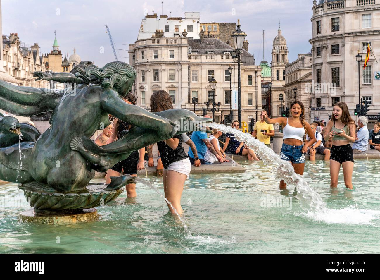 Junge Menschen kühlen sich während des heißesten Tages ab, der je in der Hauptstadt London aufgezeichnet wurde, in den Fountains am Trafalgar Square. Stockfoto