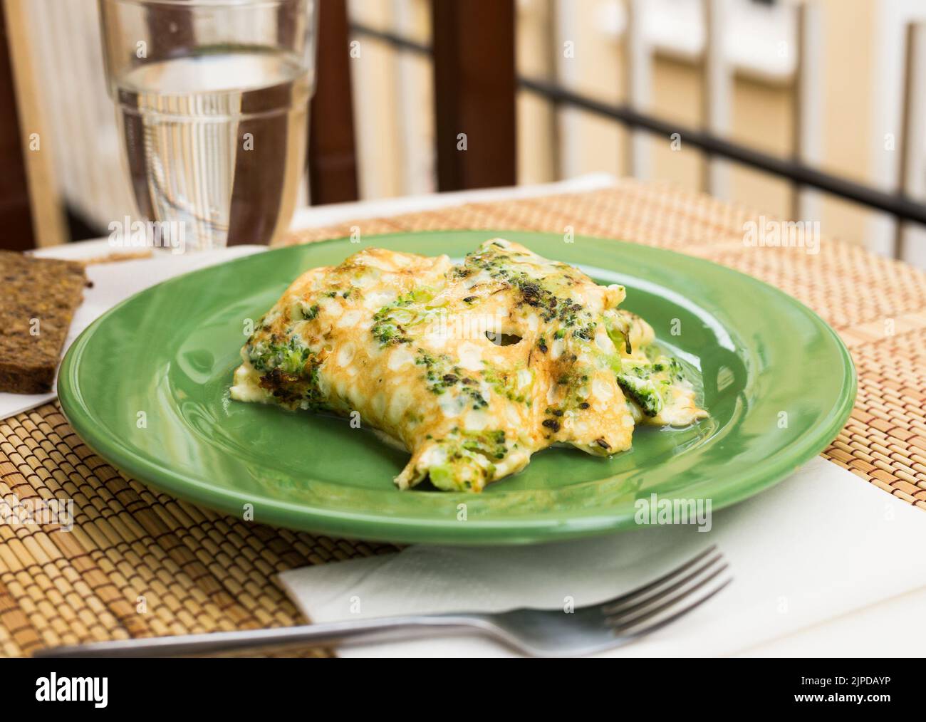 Gesundes Frühstück. Omelette mit Brokkoli auf grünem Teller Stockfoto