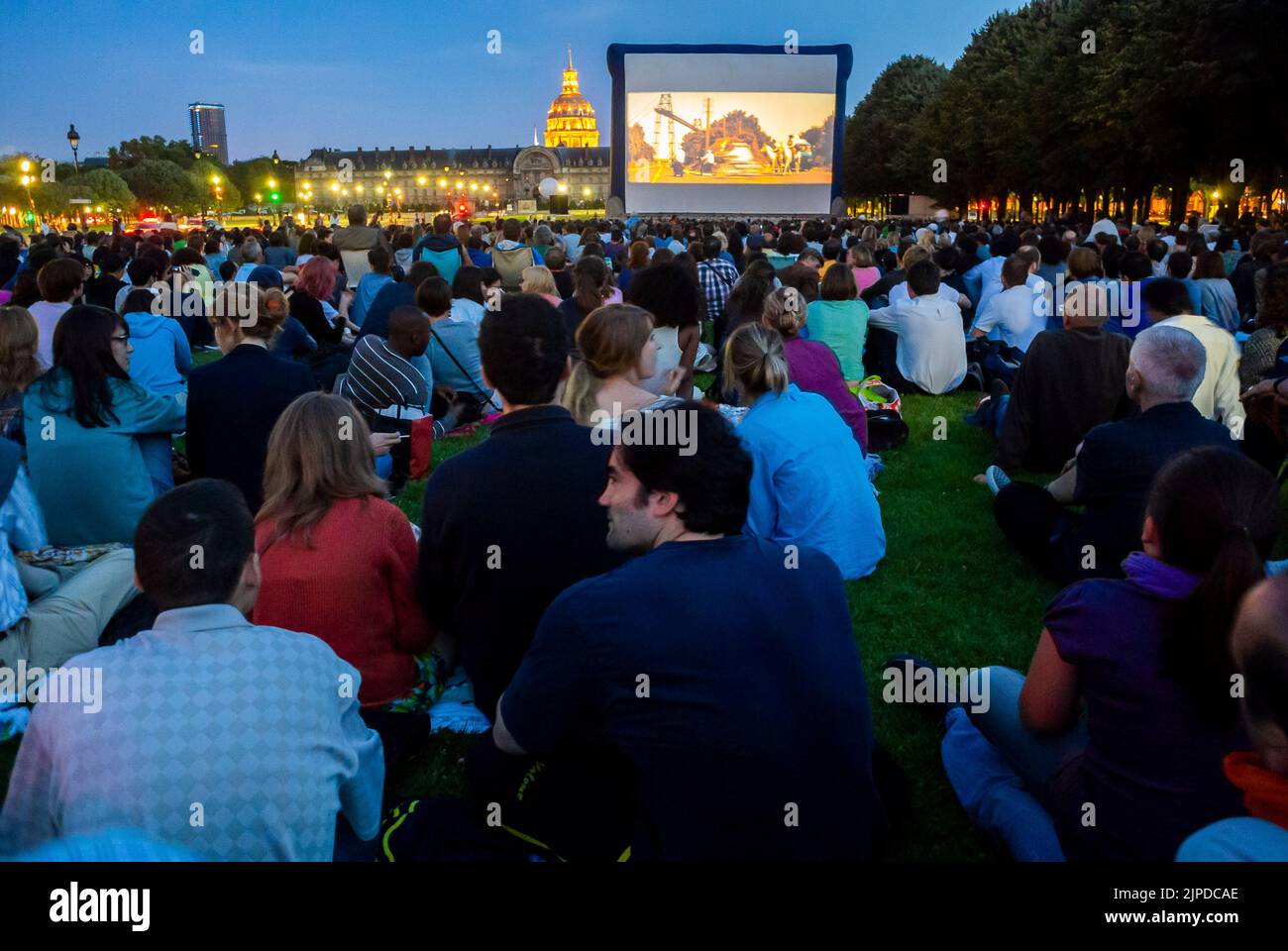 Paris, Frankreich, große Menschenmengen, sitzen auf dem Rasen, draußen nachts, Publikum von hinten bei der Open Air Cinema Show im Stadtpark Invalides Stockfoto