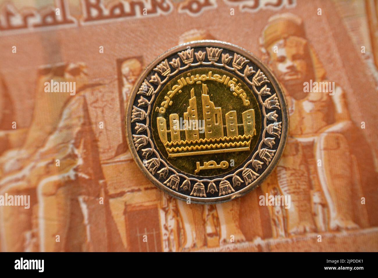 Die neuen Stadtgebäude Alamein in Ägypten von der Vorderseite des 1 LE EGP prägen ein ägyptisches Pfund Geld auf einem verschwommenen Hintergrund der Rückseite eines Stockfoto