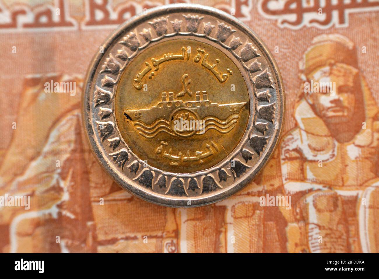 Der neue ägyptische Suez-Kanal-Projekt-Slogan von der Vorderseite der 1 LE EGP-Münze ein ägyptisches Pfund Geld auf einem verschwommenen Hintergrund der Rückseite von Stockfoto