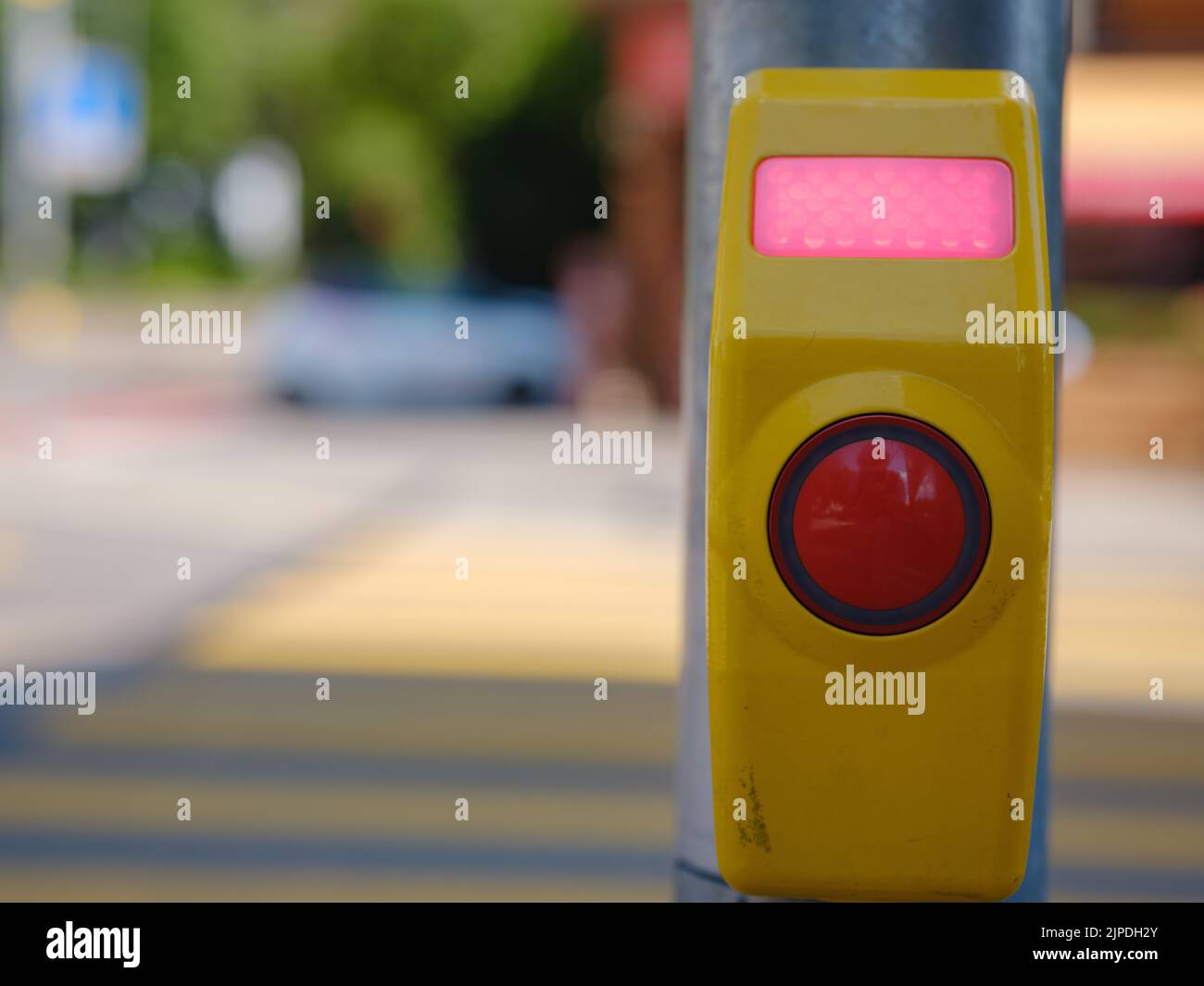 Nahaufnahme einer Signaltaste für den Fußgängerüberweg, die an einer Fußgängerüberfahrt aufgenommen wurde. Eine Ruftaste, die das Licht durchlässt. Stockfoto