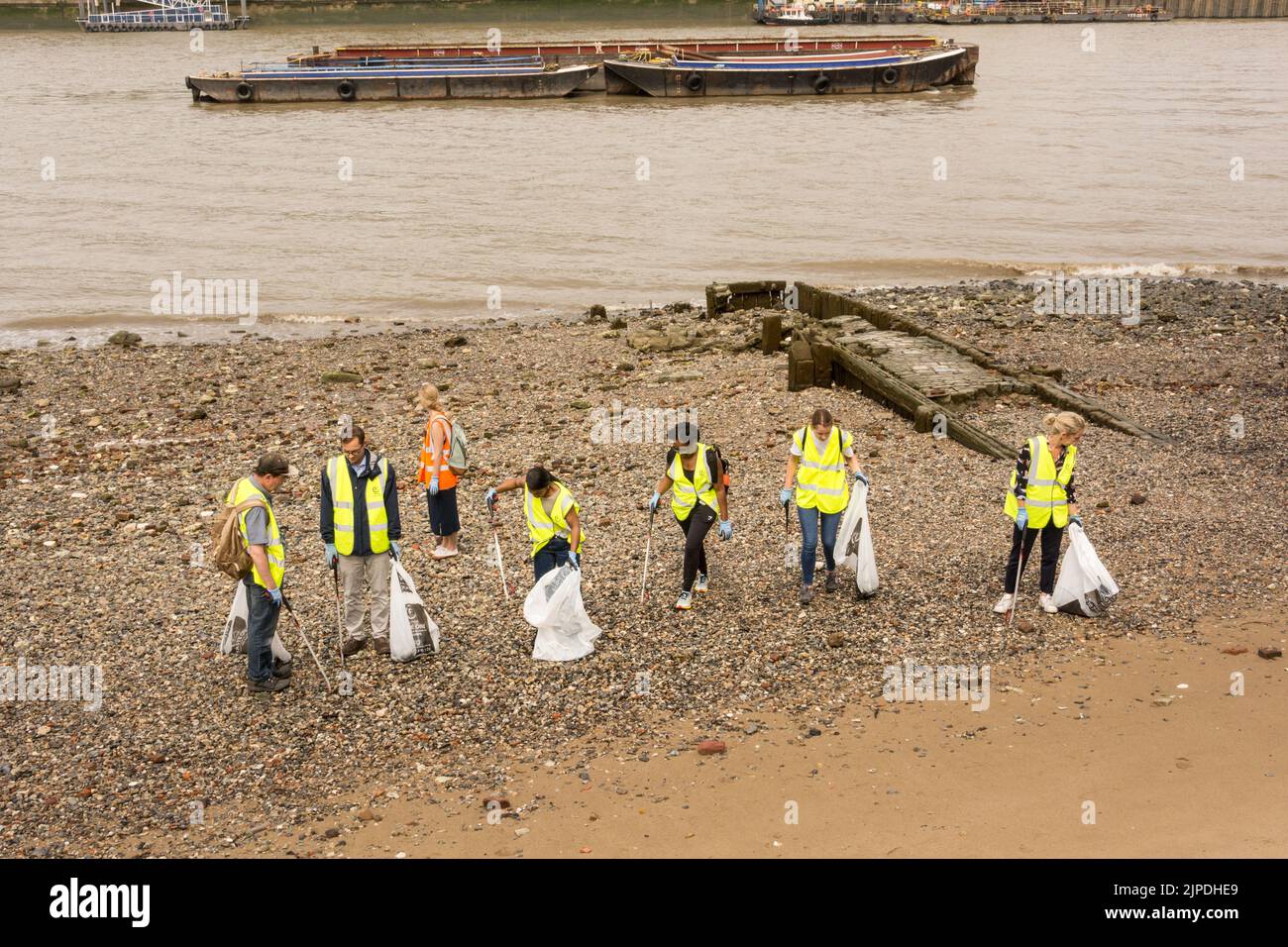 Eine Gruppe von freiwilligen Reinigungskräften auf der Themse in Gabriel's Wharf pflückt Müll und andere umweltschädliche Gegenstände Stockfoto