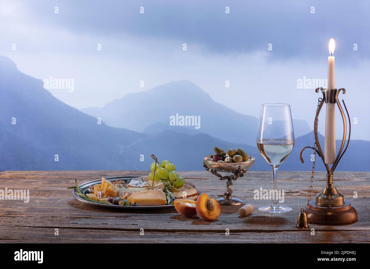 Vintage-Bild von Weinflasche, Glas gefüllt mit köstlichem Weißwein isoliert über schöne Naturlandschaft der Berge. Weinbereitung auf dem Land Stockfoto