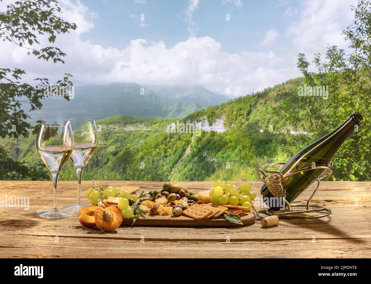 Köstlicher Weißwein, der auf einem Holztisch steht. Sommer Berge und Weinberg Landschaft Blick. Stockfoto
