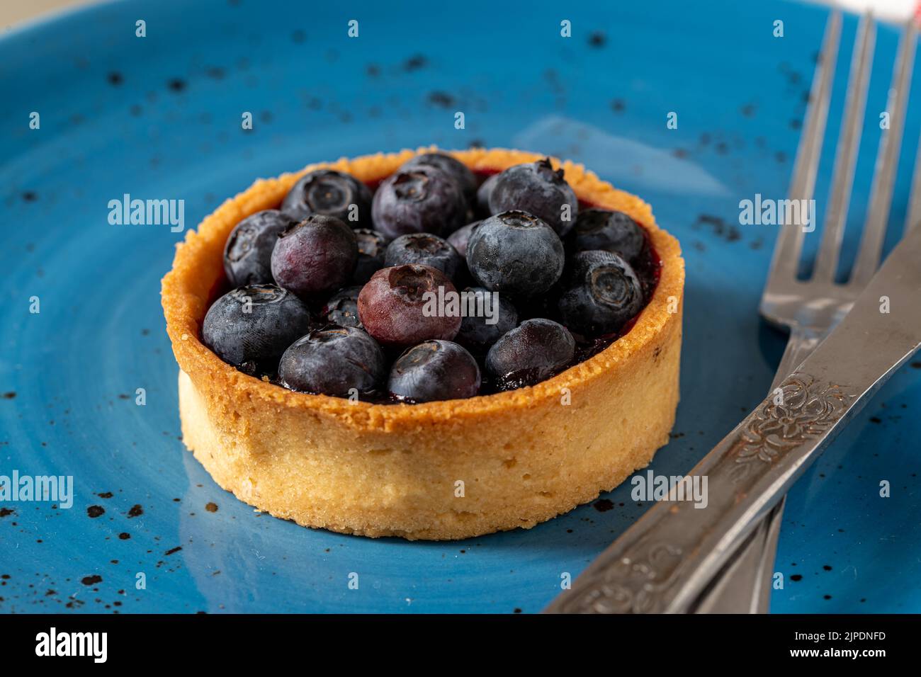 Frisch gebackene Heidelbeertarte auf einem blauen Porzellanteller Stockfoto