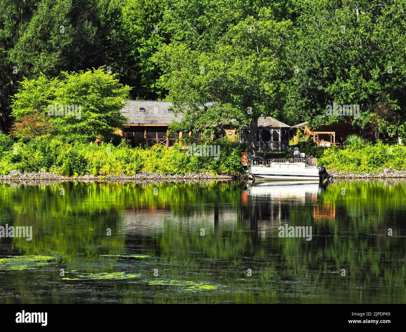 Ferienhaus mit Pavillon und Boot am Wasser Stockfoto