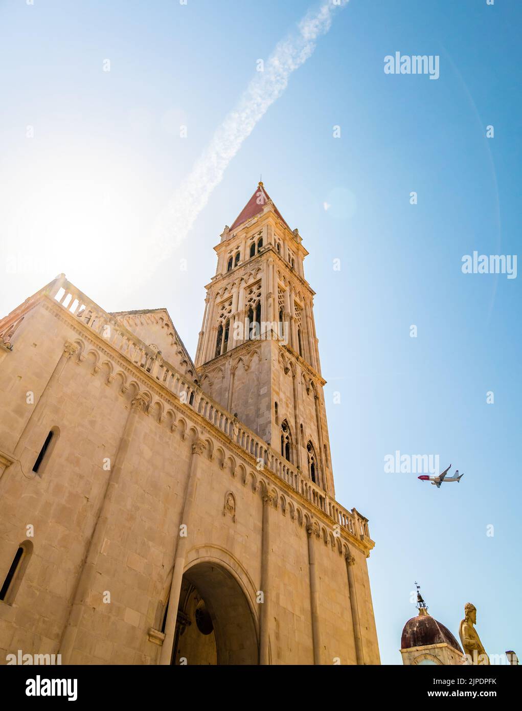 Blick auf die Kathedrale von St. Lawrence, Trogir - Kroatien. Von unten nach oben Blick auf den schönen alten Kirchturm. Das Flugzeug landet auf dem Flughafen Split. Aircr Stockfoto