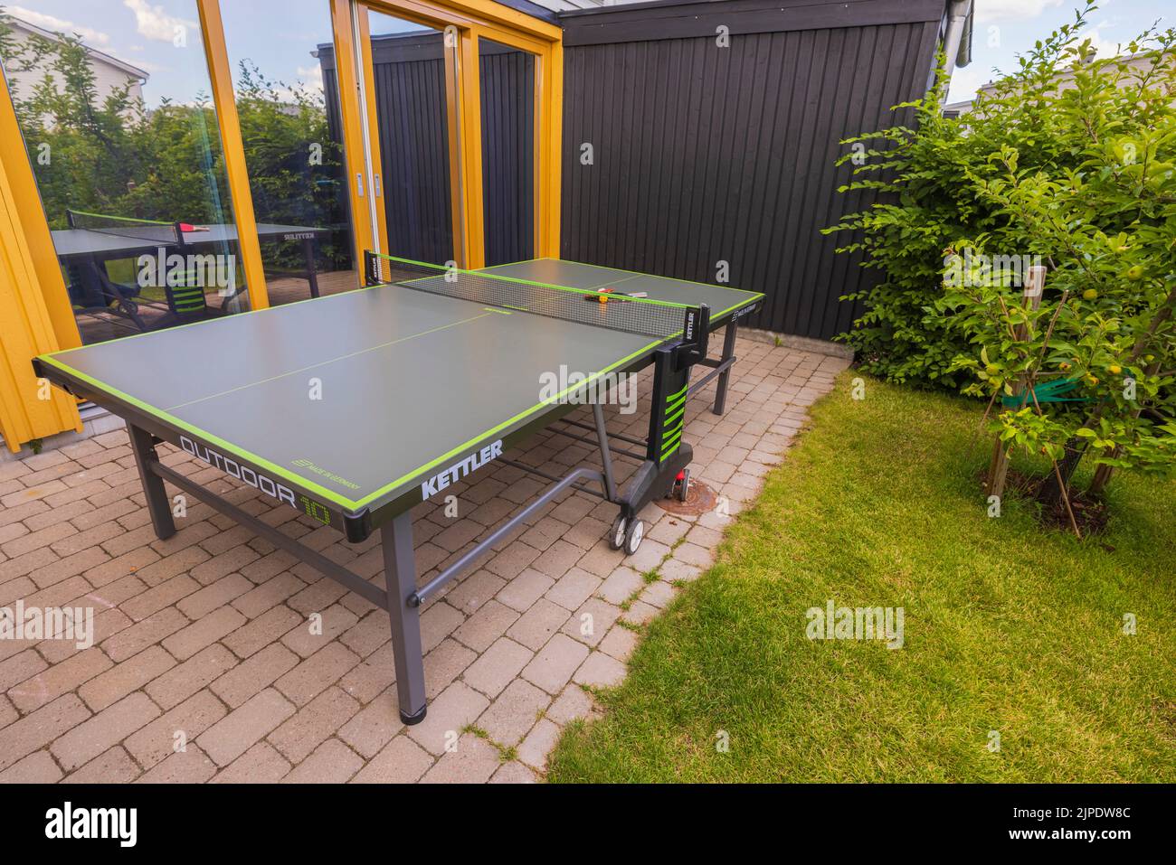 Wunderschöne Aussicht auf Tischtennis-Tennis vor dem modernen Stadthaus mit Spiegelfenstern. Schweden. Stockfoto