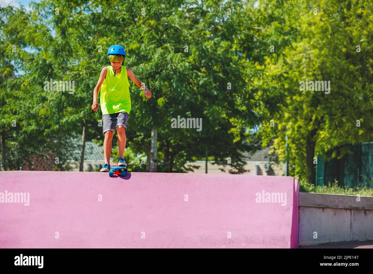 Der Teenager Junge im Skatepark steht lächelnd auf der Rampe Stockfoto