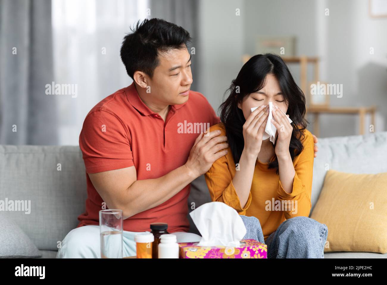 Liebevoller Ehemann, der sich zu Hause um die kranke Frau kümmert Stockfoto