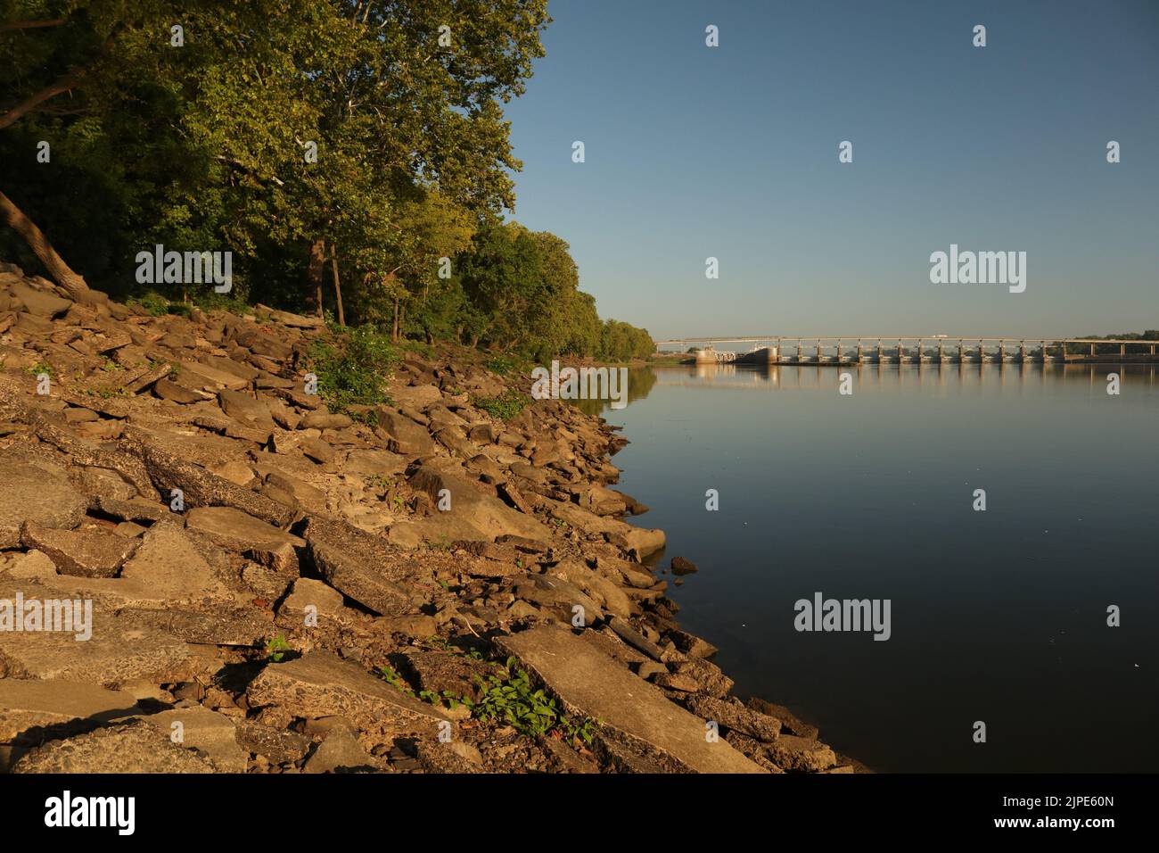 Ufer des Arkansas River mit Brücke im Hintergrund Stockfoto