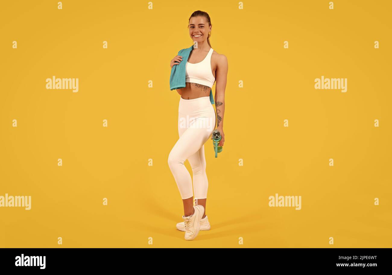 Sportfrau mit Wasserflasche auf gelbem Hintergrund Stockfoto