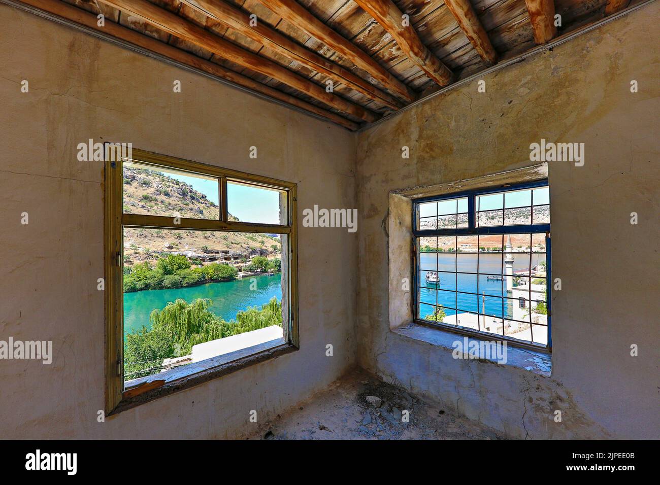 Der Eufratfluss und das Minarett, das unter dem Wasser des Birecik-Staudamms durch die Fenster eines verlassenen Hauses in Halfeti, Türkei, blieb Stockfoto