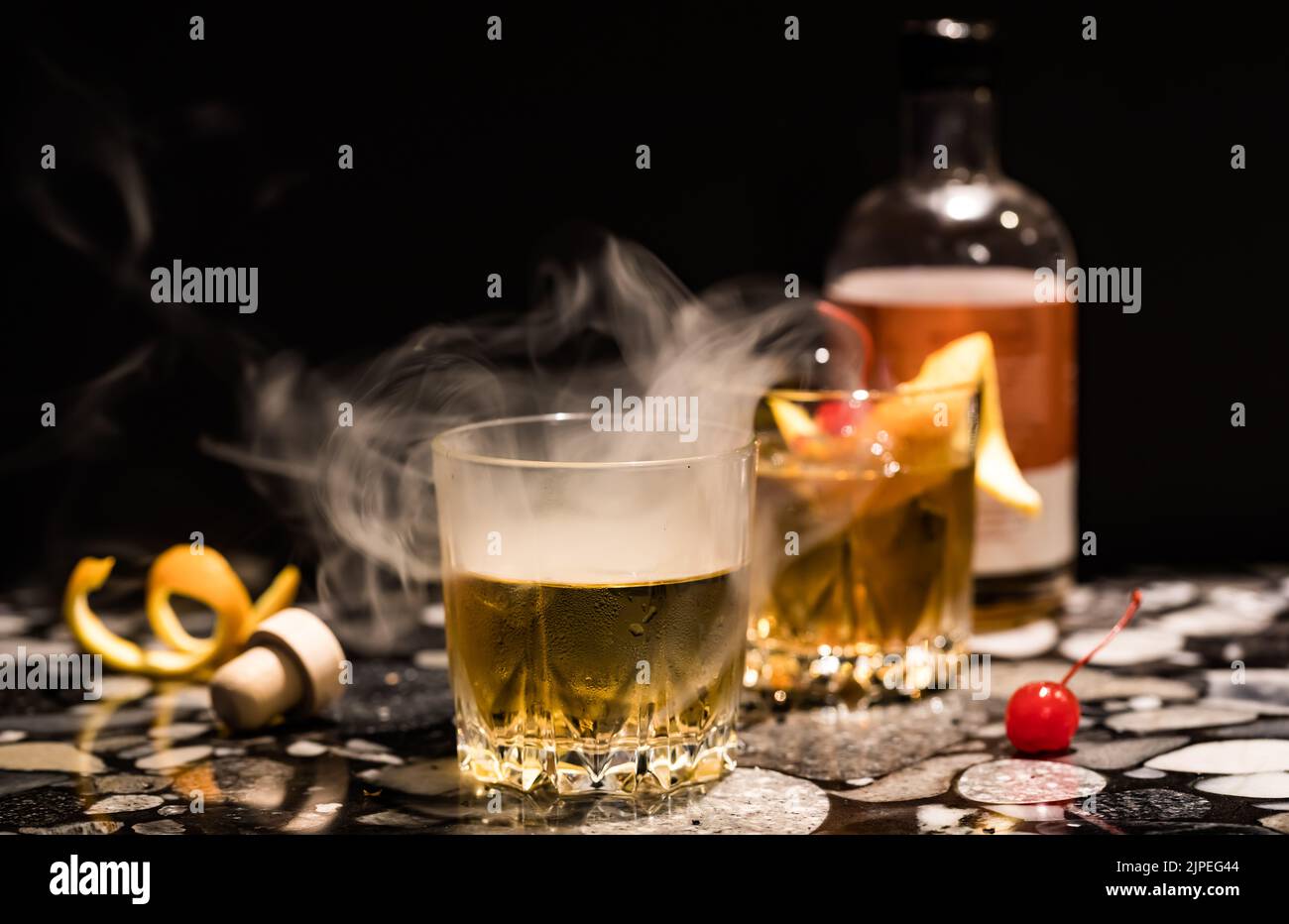 Rauch, der aus einem altmodischen Cocktail strömt. Selektiver Fokus vor dem Glas. Stockfoto
