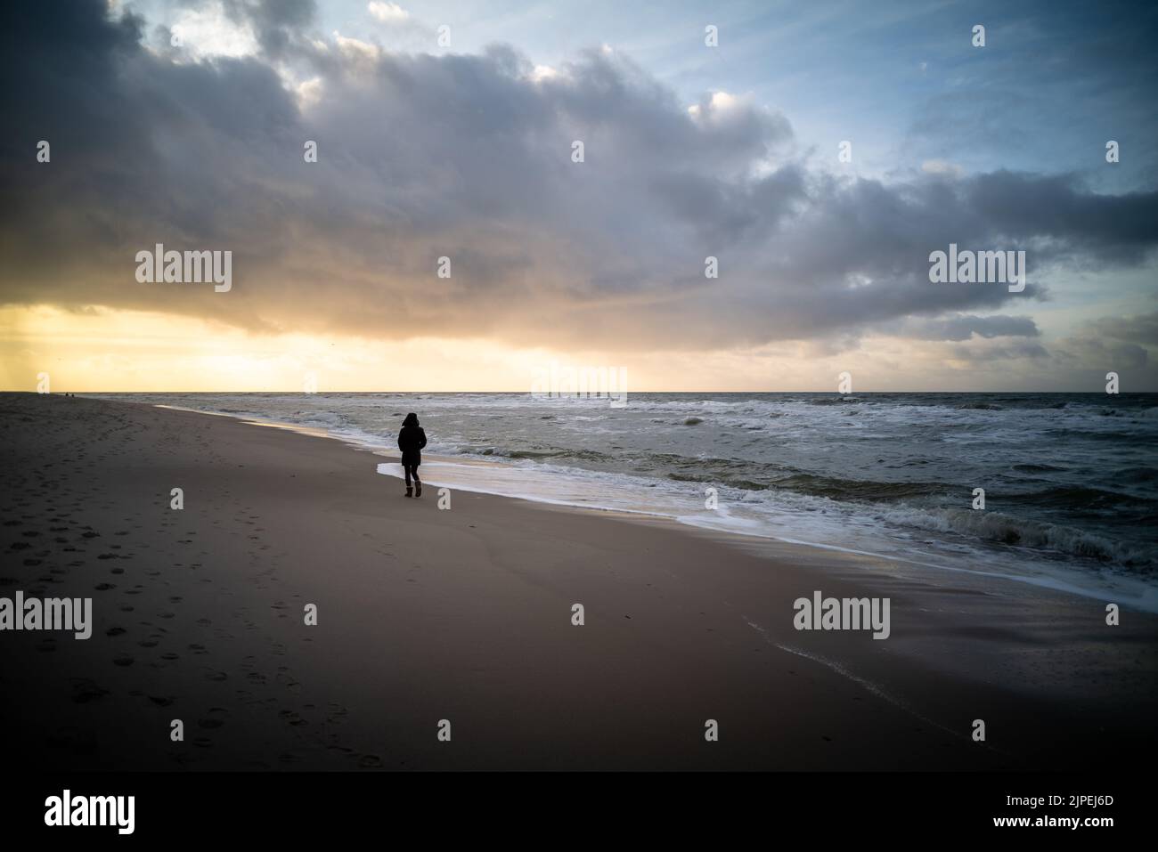Frau lief alleine am Strand während des Sonnenuntergangs, Sylt, Deutschland. Stockfoto
