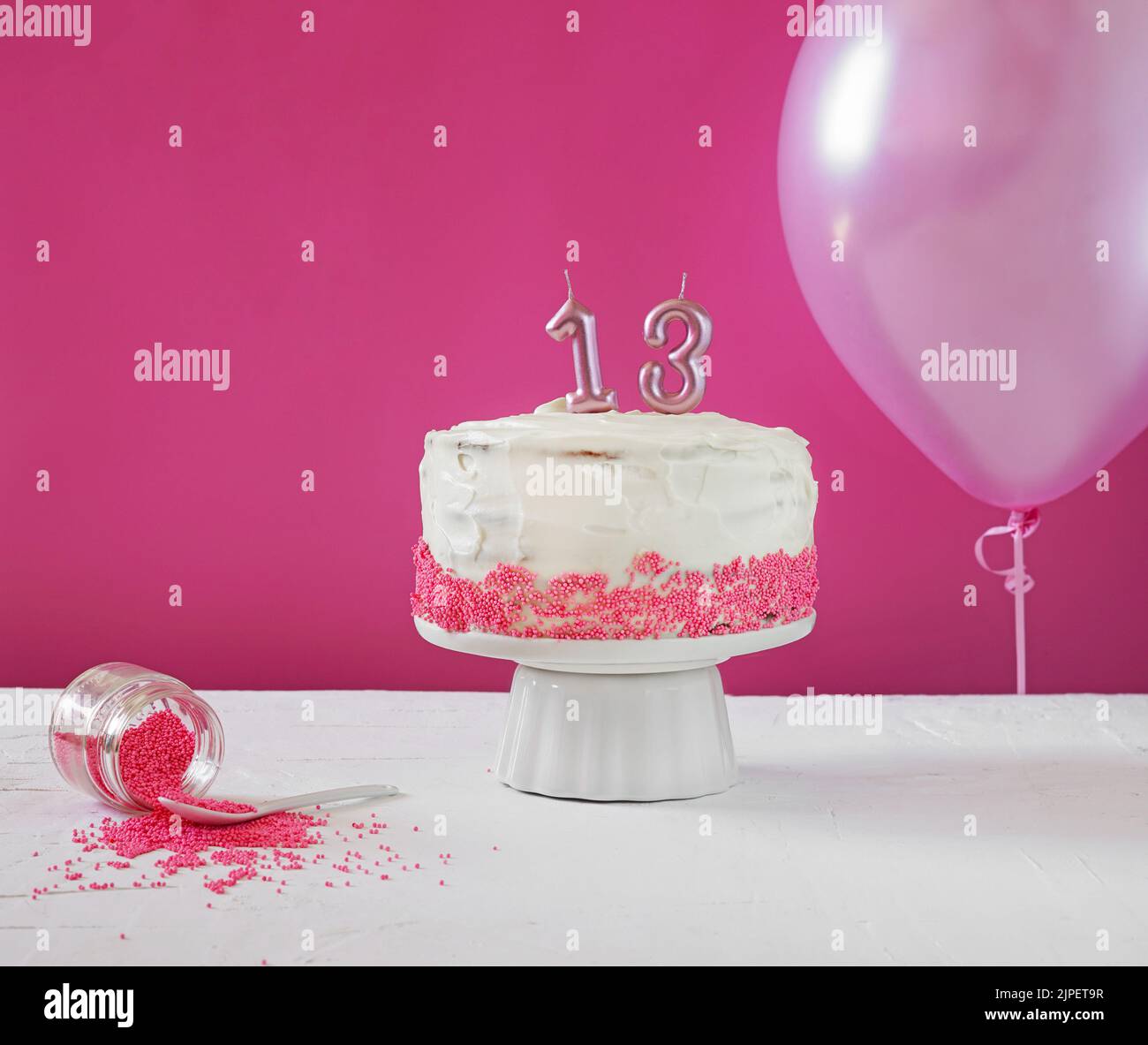 Kuchen mit Creme und Nummer 13 für einen Geburtstag auf einem rosa Hintergrund, Kopierplatz, Feiertagshintergrund. Alles gute zum Geburtstag für dreizehn Jahre Stockfoto