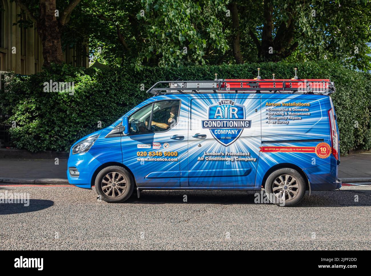 London, Großbritannien - 5. Juli 2022: Nahaufnahme, The Air Conditioning Company Van in der Albany Street, weiß und gelb auf blau, mit grünem Laub. Private Komp Stockfoto