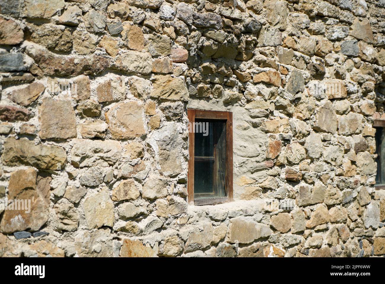 Ein kleines Holzfenster in der Steinmauer eines alten Hauses  Stockfotografie - Alamy