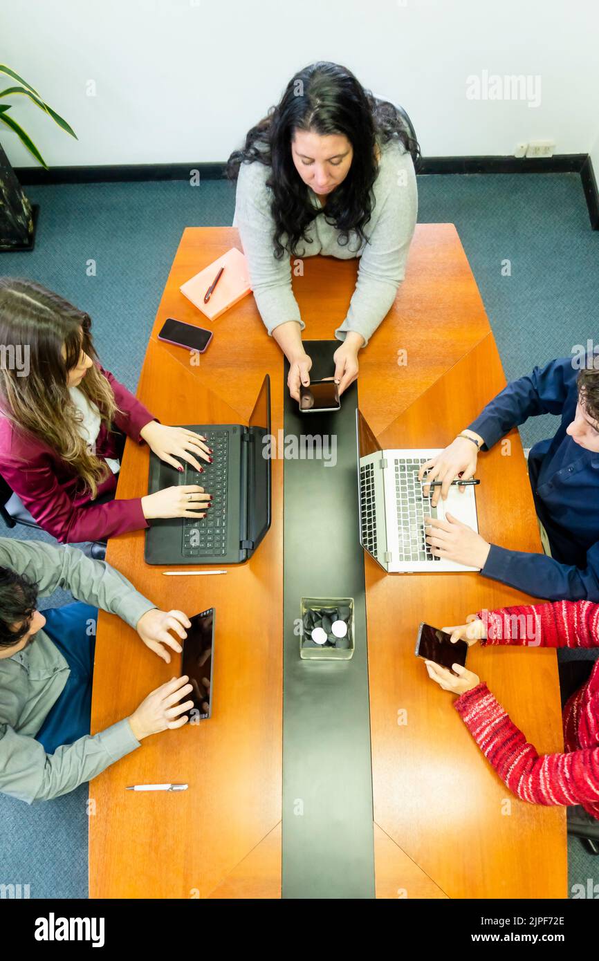 Draufsicht auf eine Gruppe von Mitarbeitern, die am Büromeetingtisch sitzen und Brainstorming sprechen Stockfoto