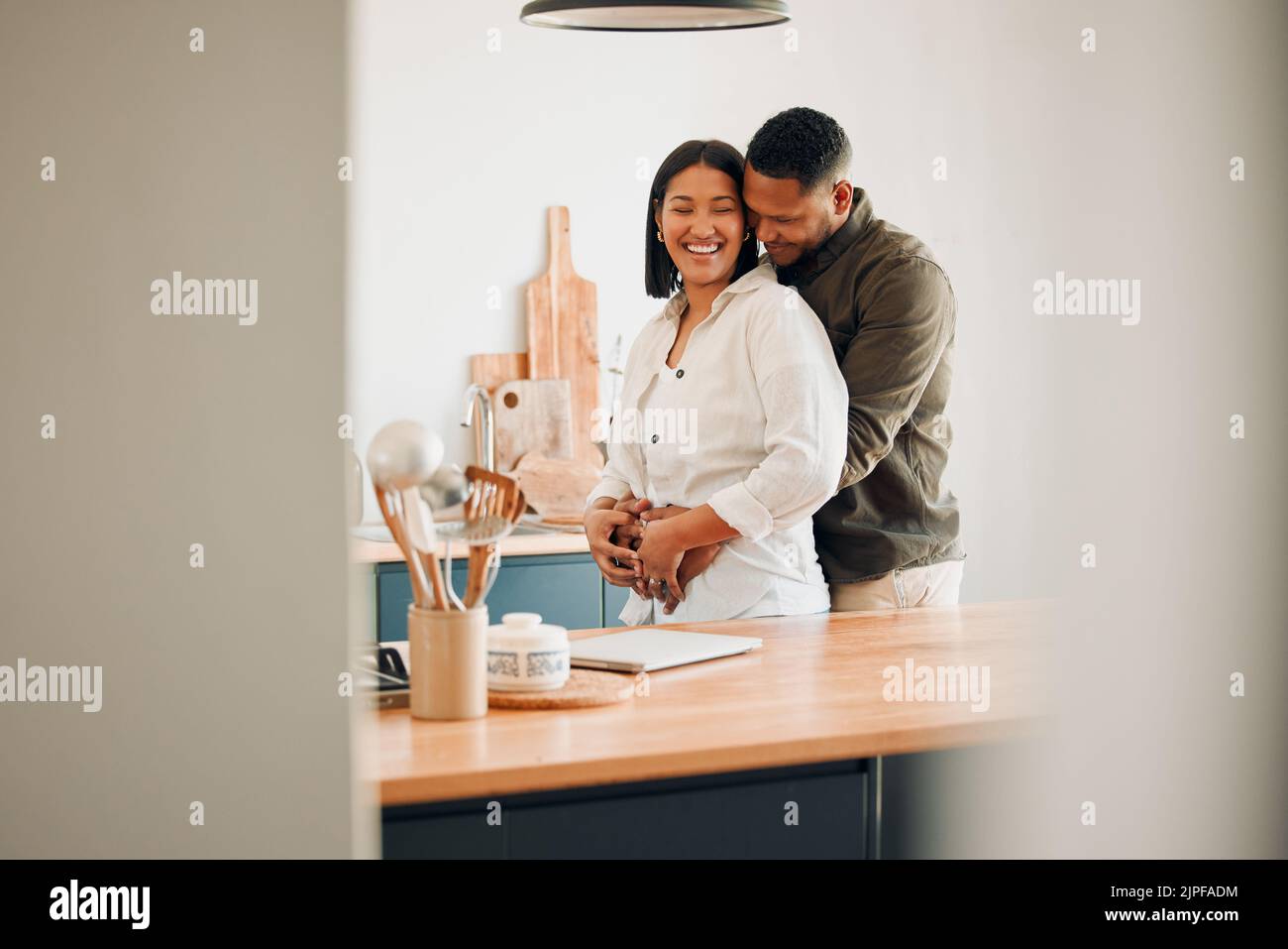 Umarmendes, glückliches und aufgerugtes Paar, das viel Zeit miteinander verbringt und sich zu Hause entspannt. Liebevolle, entspannte und liebevolle afrikanische Liebhaber umarmen Stockfoto