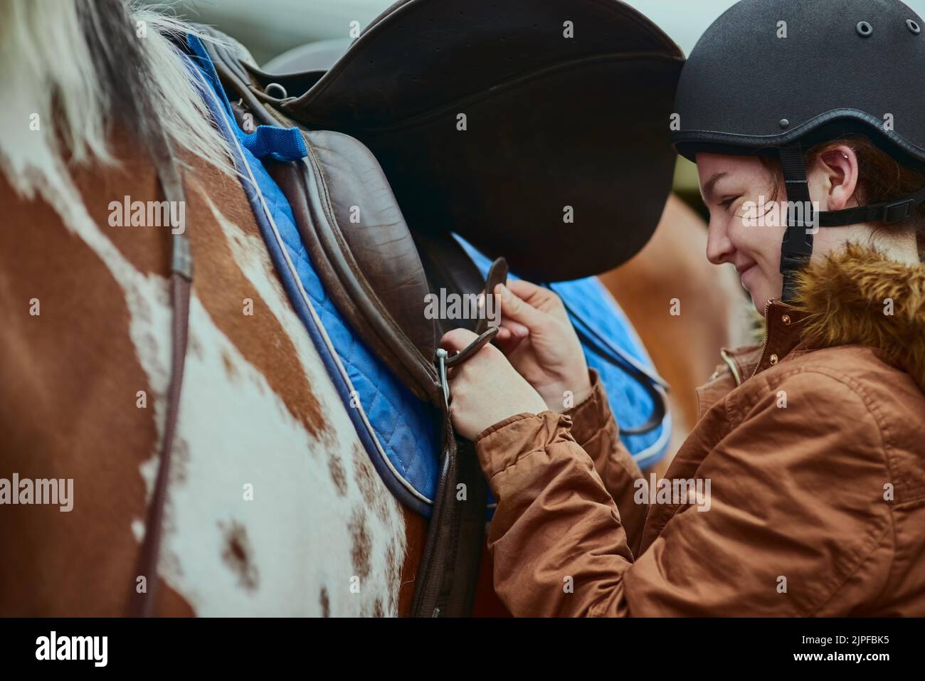 Zeit zum Pony. Ein Teenager-Mädchen bereitet sich darauf vor, ihr Pony auf einer Farm zu reiten. Stockfoto