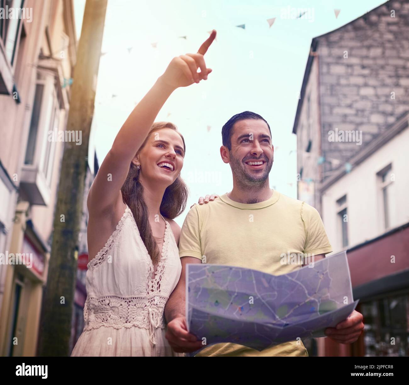 Sehen Sie sich die Dinge an, die Sie sehen müssen. Ein glückliches junges Paar, das eine Karte liest, während es gemeinsam eine fremde Stadt erkundet. Stockfoto