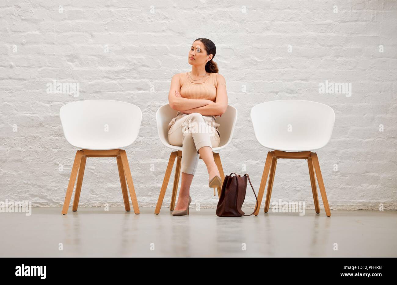 Beschäftigung, Einstellung und Rekrutierung mit einer jungen Geschäftsfrau, die auf einem Stuhl sitzt und auf ihr Interview mit der Personalabteilung wartet. Weibliche Shortlist Stockfoto