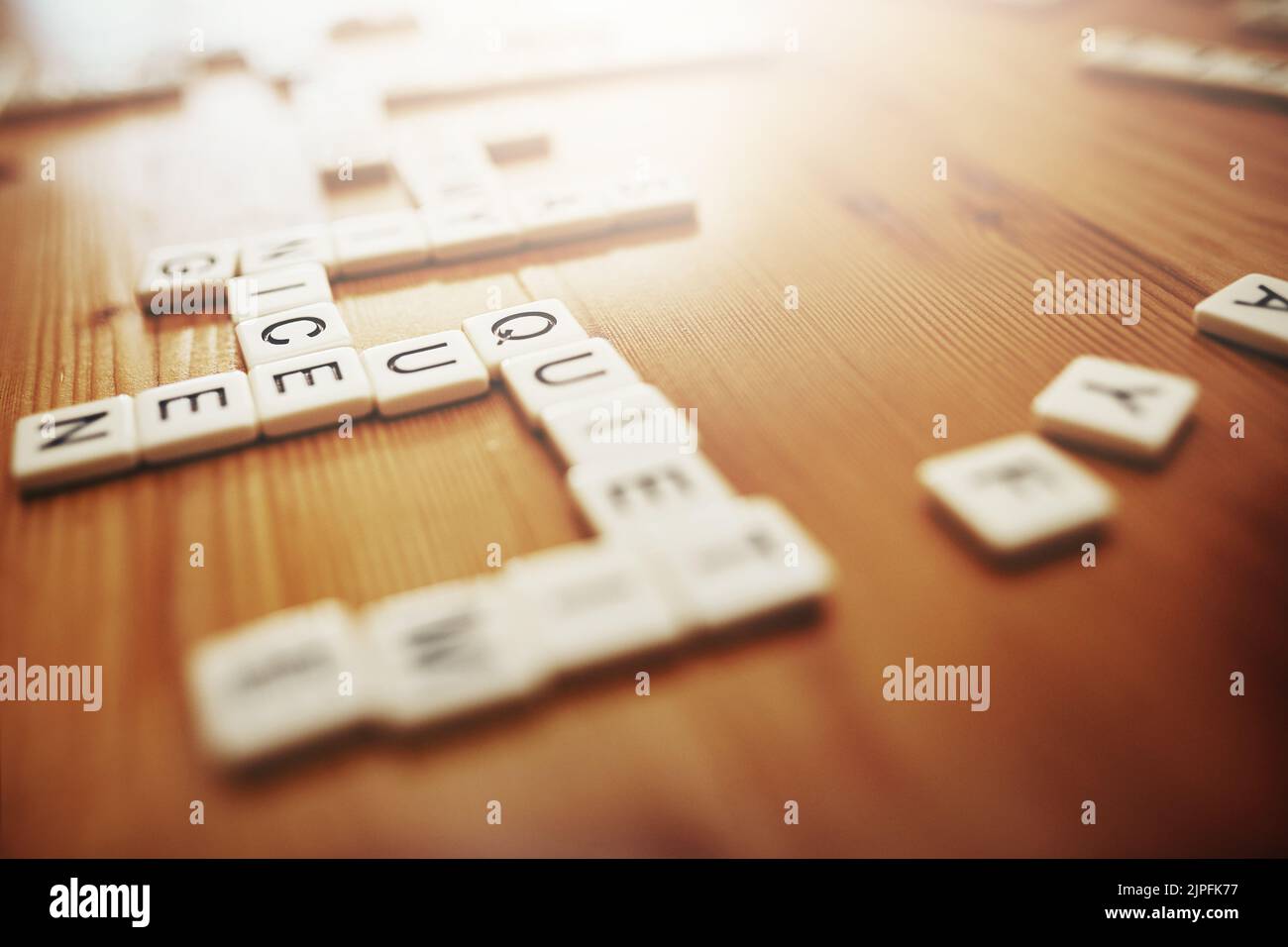 Scrabble, Brettspiele und Spaß mit Stücken auf einem Tisch machen Wörter, Text und Sprache, während ein Spiel zu spielen. Rechtschreibung, Unterhaltung und Erholung mit Stockfoto