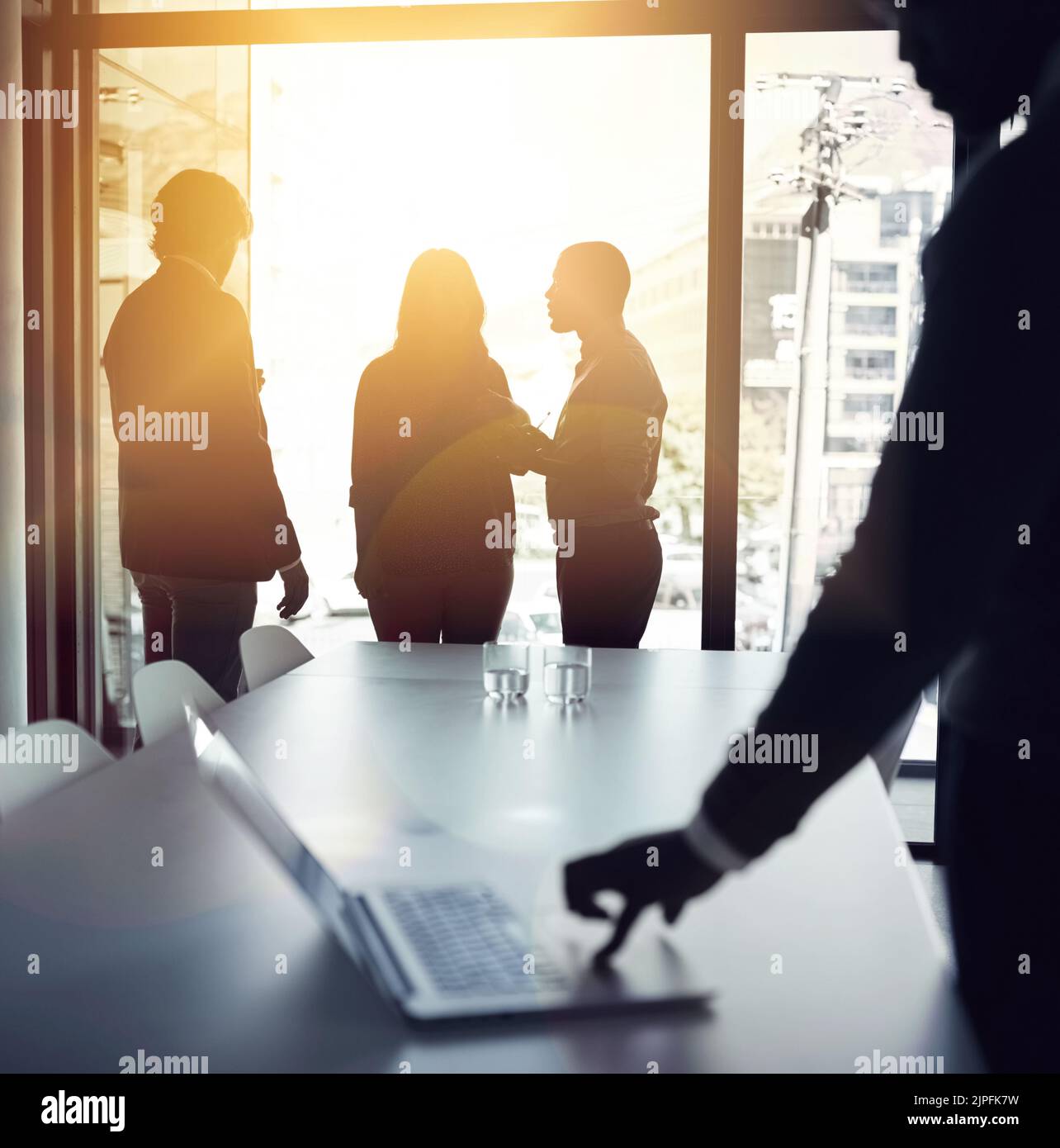 Planungsstrategie für eine erfolgreiche und glänzende Zukunft mit einem Team von Geschäftsleuten, das in einem Konferenzgespräch mit einem Fackel spricht. Hintergrundbeleuchtete Gruppe von Stockfoto