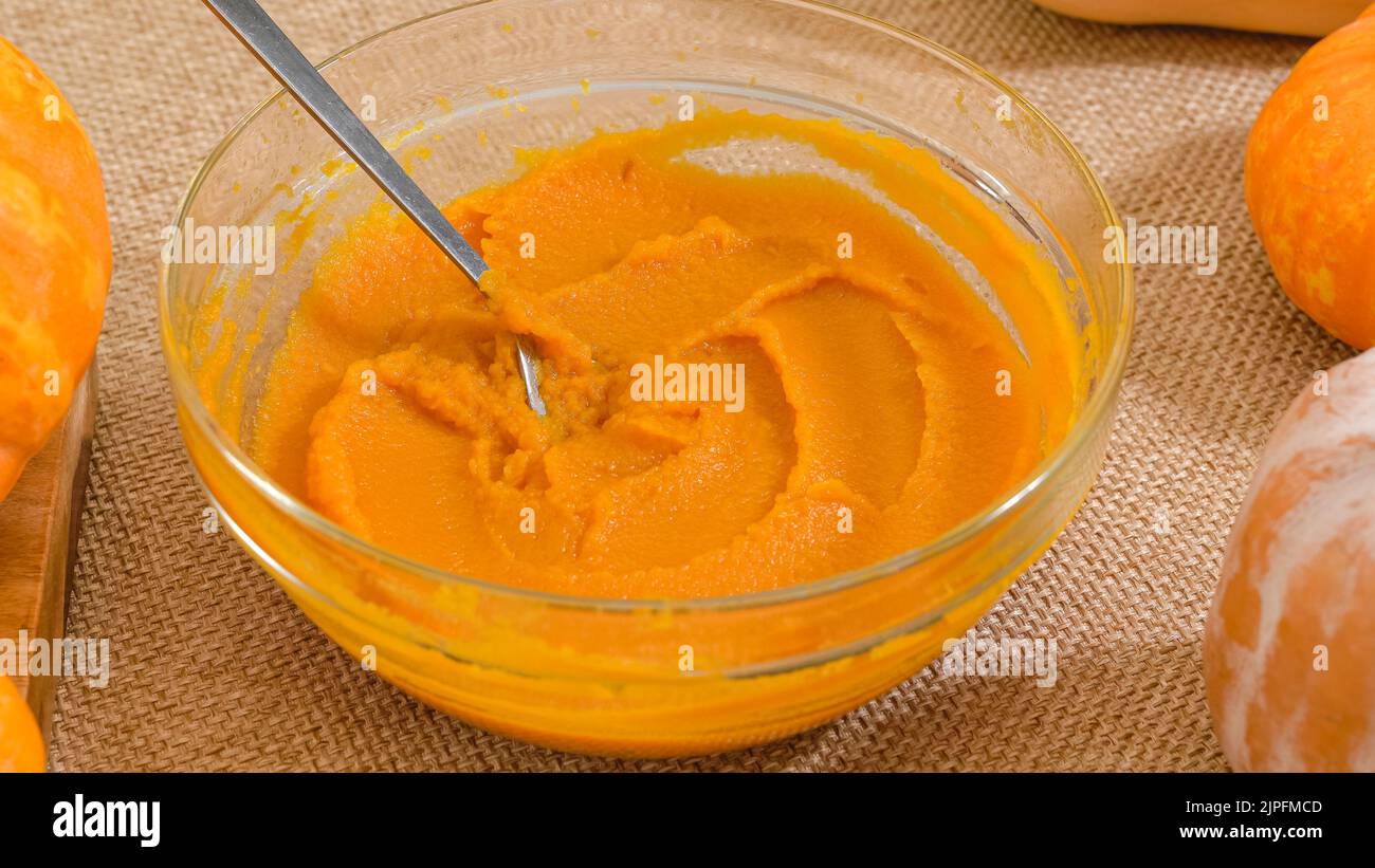 Frisches Kürbispüree in einer Glasschüssel Nahaufnahme auf rustikalem Hintergrund. Kürbispüree aus Scrach machen, Schritt für Schritt Rezept Stockfoto