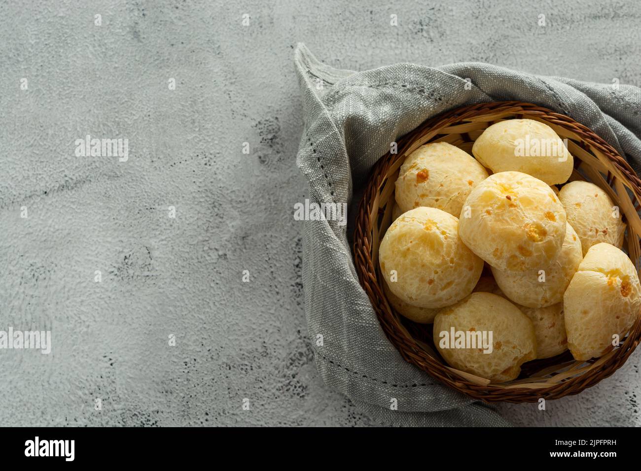 Korb mit Käsebrot oder Käsebun auf Steintisch Stockfoto