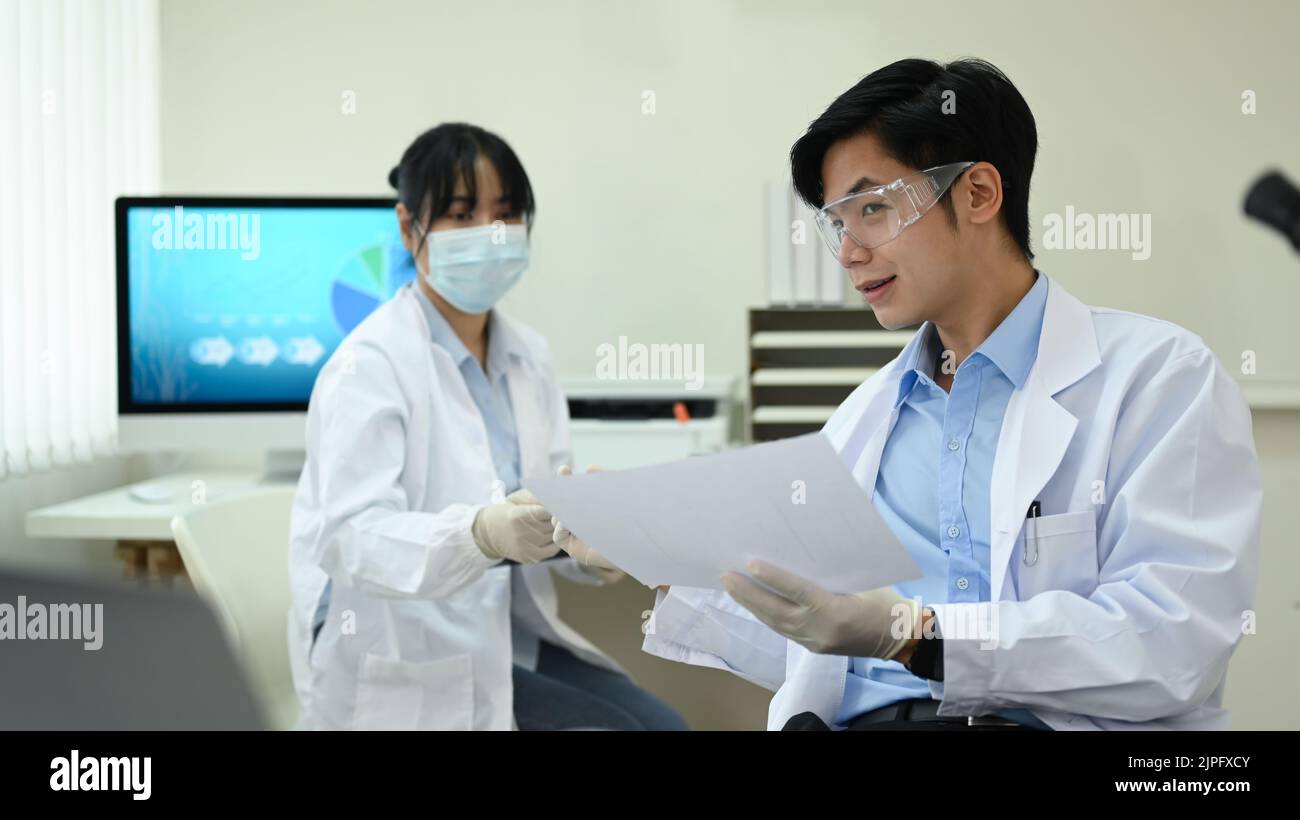 Team von Industriewissenschaftlern in weißen Mänteln, die im Forschungslabor zusammenarbeiten Stockfoto