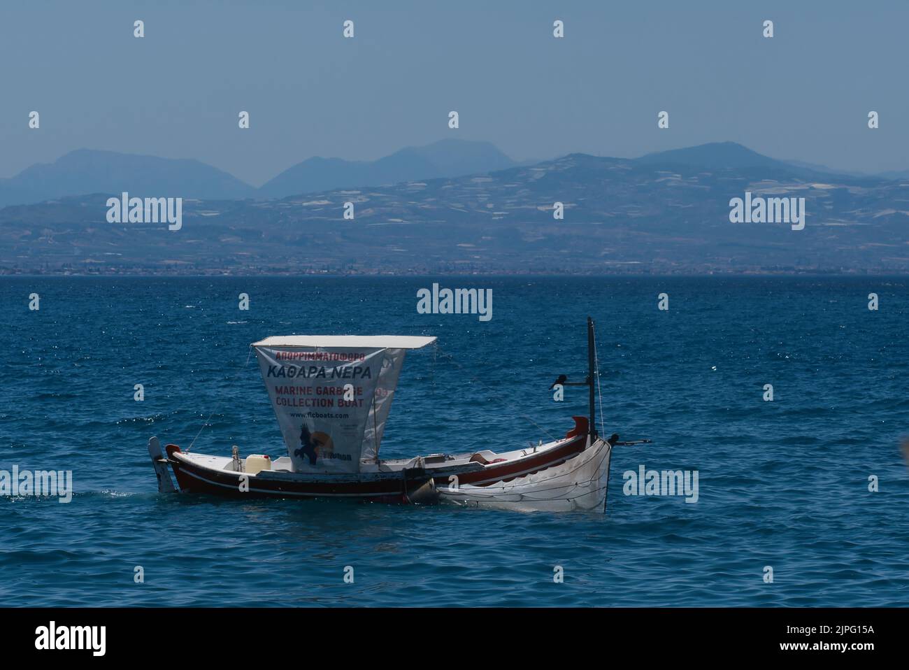 Müllsammler in einem kleinen Boot in Loutraki Griechenland im Sommer Stockfoto