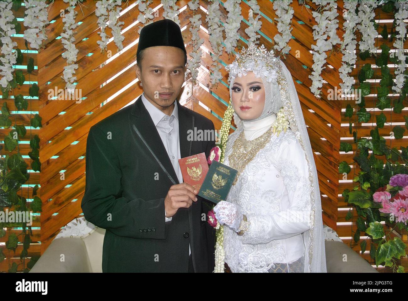 Tegal, INDONESIEN - 22. Dezember 2019: Die muslimische Braut und der muslimische Bräutigam zeigen das Ehebuch. Stockfoto
