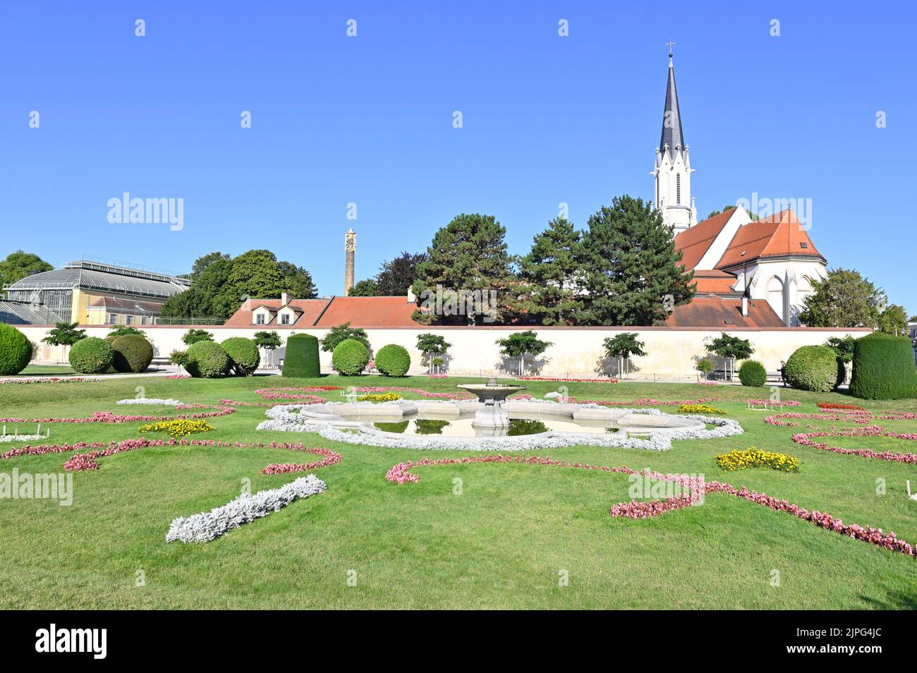 Wien, Österreich. Blick vom Schlosspark Schönbrunn auf das Wüstenhaus (L) und die Pfarrkirche Maria Hietzing (R) Stockfoto