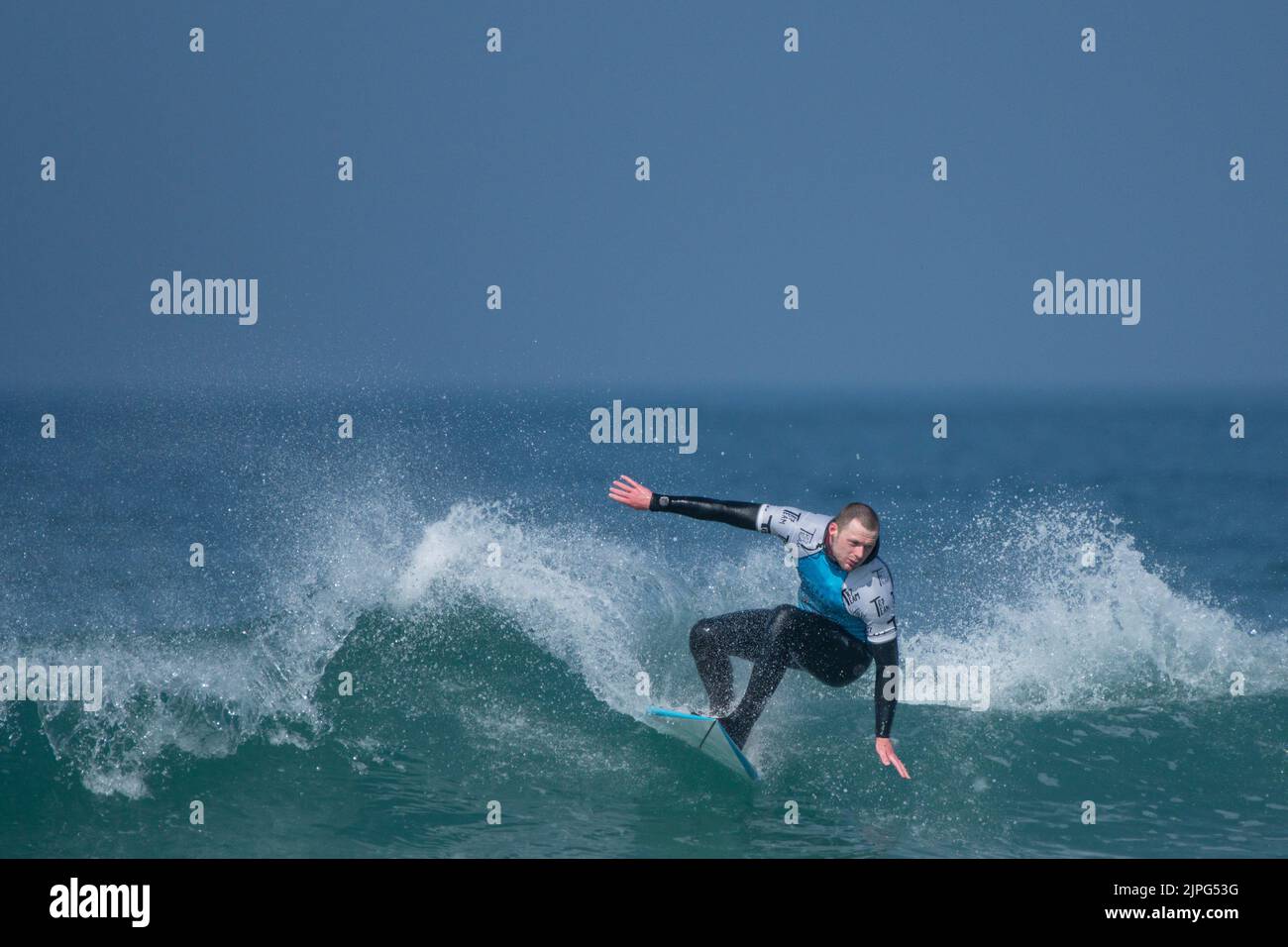 Ein männlicher Surfer, der an einem Surfwettbewerb im Fistral in Newquay in Cornwall in Großbritannien teilhat. Stockfoto